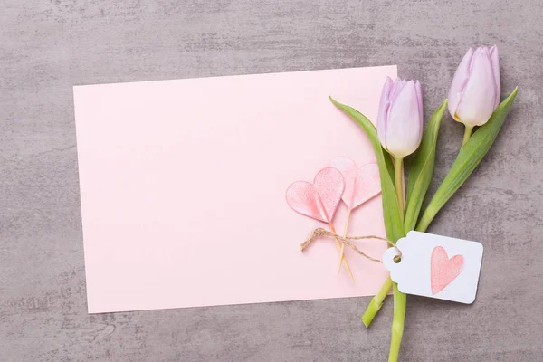 Frühling Grußkarte, rosa Farbe Tulpen auf dem grauen Hintergrund. — Stockfoto