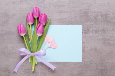 Bahar tebrik kartı, gri arka plan üzerinde pembe renk laleler.