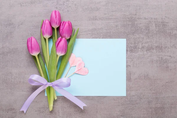 Frühling Grußkarte, rosa Farbe Tulpen auf dem grauen Hintergrund. — Stockfoto