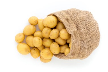 Ahşap arka planda taze çiğ patates çuvalı.