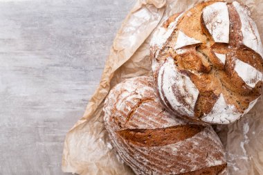 Ahşap masa arkasında pişmiş ekmek çeşitleri.