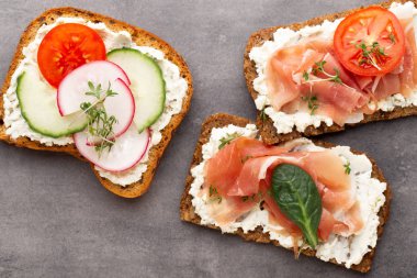 Sandviç tahıl ekmek ve karanlık mermer zemin üzerine salam