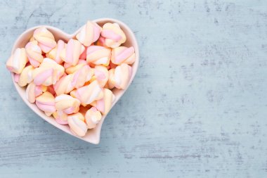 Marshmallow boşaltmak mavi zemin üzerine. Düz yatıyordu veya üst 