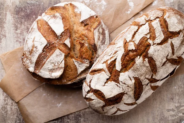 Ahşap masa arkasında pişmiş ekmek çeşitleri.