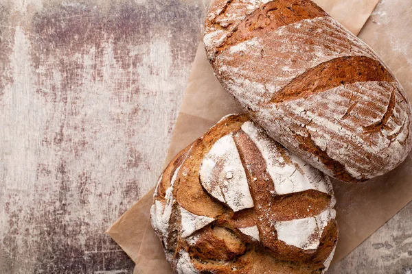 Ahşap masa arkasında pişmiş ekmek çeşitleri.