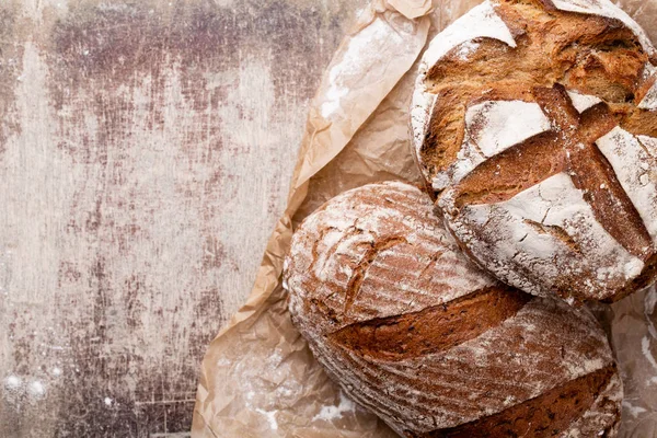 Ahşap masa arkasında pişmiş ekmek çeşitleri.