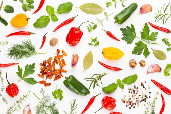 Baharatlı bitkisel yapraklar ve beyaz arka planda kırmızı biber. Vegeta