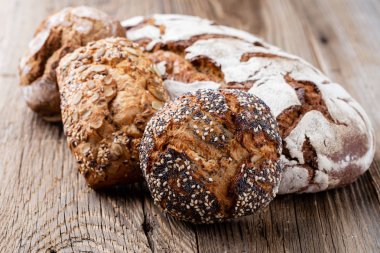 Ahşap arka planda altın kırsal ekmek ve çörekler