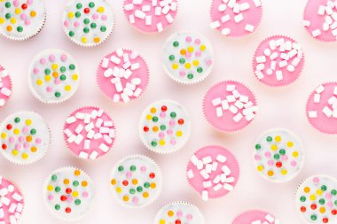 Beyaz arkaplanda renkli kekler. 