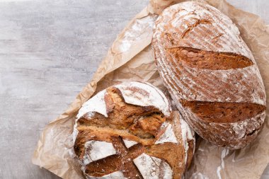 Ahşap masa arkasında pişmiş ekmek çeşitleri.