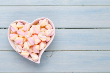 Marshmallow boşaltmak mavi zemin üzerine. Düz yatıyordu veya üst 