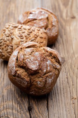 Ahşap arka planda altın kırsal ekmek ve çörekler