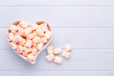 Marshmallow boşaltmak mavi zemin üzerine. Düz yatıyordu veya üst 