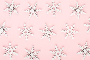 Noel arkaplanı. Beyaz kar süslemeleri pembe bir sırtüstü