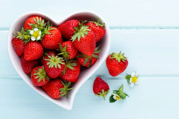 Çilekli kalp. Beyaz ahşap ta tabakta taze çilek