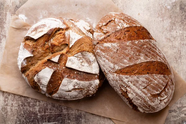 Ahşap masa arkasında pişmiş ekmek çeşitleri.