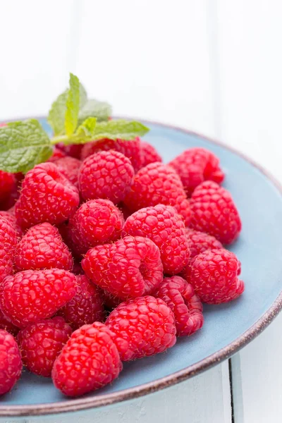 Vintage bir arka plan üzerine bir tabak içinde taze frambuaz. 