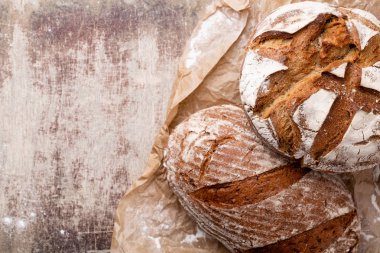 Ahşap masa arkasında pişmiş ekmek çeşitleri.