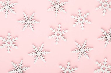 Noel arkaplanı. Beyaz kar süslemeleri pembe bir sırtüstü