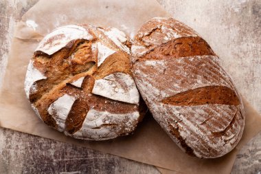 Ahşap masa arkasında pişmiş ekmek çeşitleri.