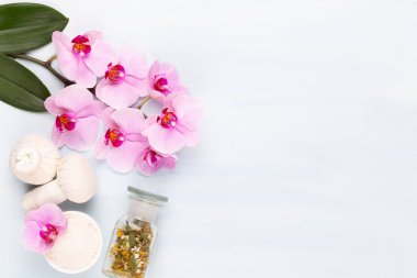 Deniz tuzu, aromaterapi yağı şişelerde ve orkide antika ahşap.