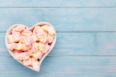 Marshmallow boşaltmak mavi zemin üzerine. Düz yatıyordu veya üst 