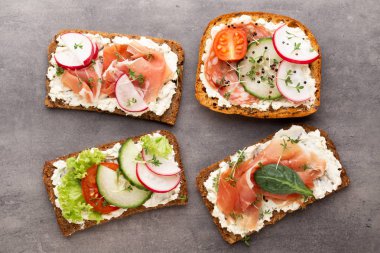 Sandviç tahıl ekmek ve karanlık mermer zemin üzerine salam