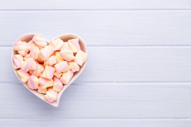 Marshmallow boşaltmak mavi zemin üzerine. Düz yatıyordu veya üst 