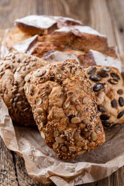 Ahşap arka planda altın kırsal ekmek ve çörekler