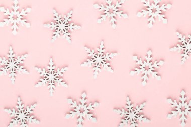 Noel arkaplanı. Beyaz kar süslemeleri pembe bir sırtüstü