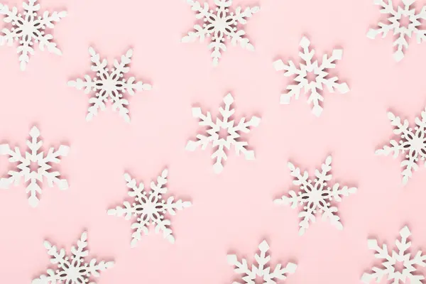 Kerst achtergrond. Witte sneeuw decoraties op een roze achtergrond — Stockfoto