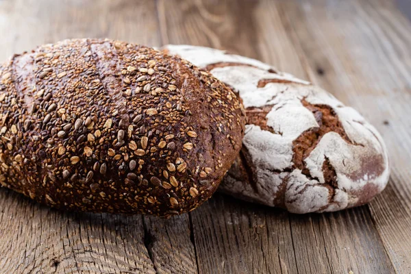 Ahşap arka planda altın kırsal ekmek ve çörekler