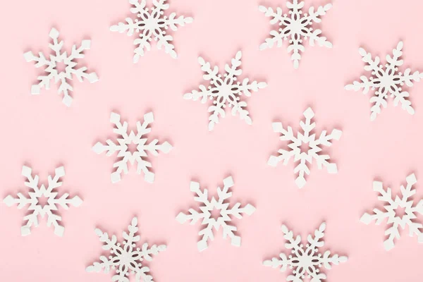 Noel arkaplanı. Beyaz kar süslemeleri pembe bir sırtüstü — Stok fotoğraf