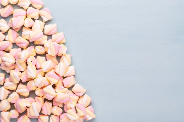 Marshmallows na modrém podkladu s copyspace. Plochou ležel nebo horního — Stock fotografie