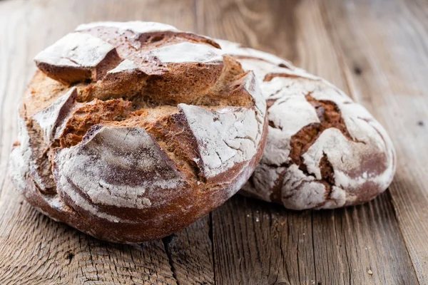 Ahşap arka planda altın kırsal ekmek ve çörekler