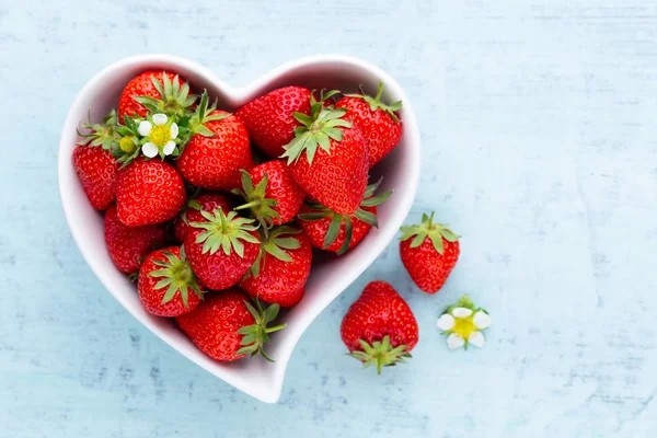 Çilekli kalp. Beyaz ahşap ta tabakta taze çilek
