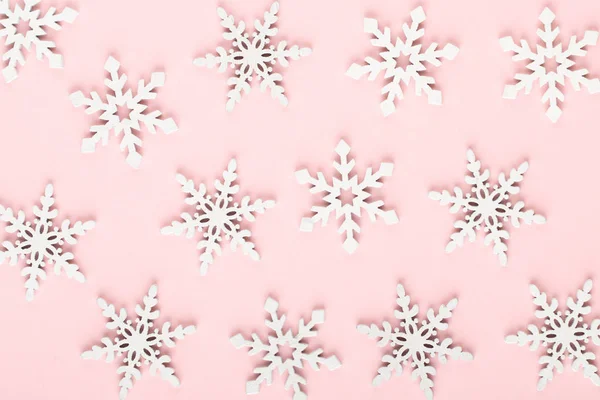 Fondo de Navidad. Decoraciones de nieve blanca sobre un fondo rosa — Foto de Stock