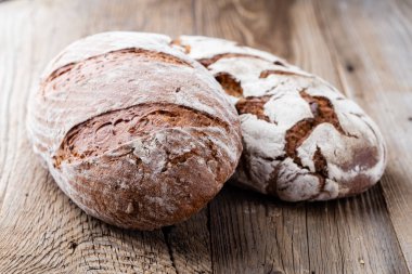 Ahşap arka planda altın kırsal ekmek ve çörekler