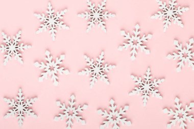Noel arkaplanı. Beyaz kar süslemeleri pembe bir sırtüstü