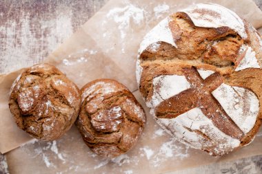Ahşap arka planda altın kırsal ekmek ve çörekler