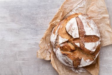 Ahşap masa arkasında pişmiş ekmek çeşitleri.