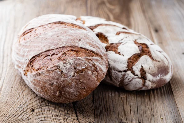 Ahşap arka planda altın kırsal ekmek ve çörekler