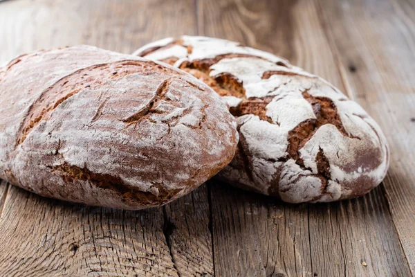 Ahşap arka planda altın kırsal ekmek ve çörekler