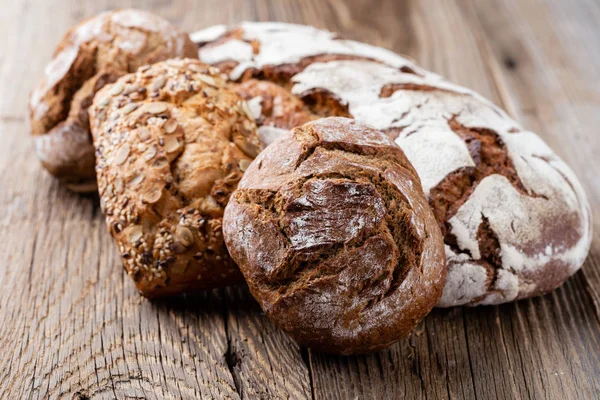 Ahşap arka planda altın kırsal ekmek ve çörekler