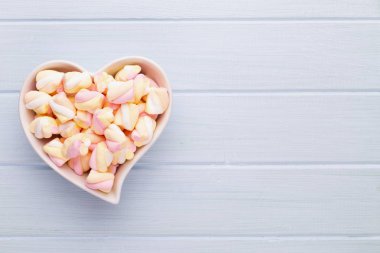 Marshmallow boşaltmak mavi zemin üzerine. Düz yatıyordu veya üst 