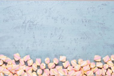 Marshmallow boşaltmak mavi zemin üzerine. Düz yatıyordu veya üst 