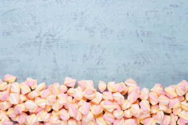 Marshmallow boşaltmak mavi zemin üzerine. Düz yatıyordu veya üst 