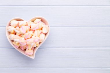 Marshmallow boşaltmak mavi zemin üzerine. Düz yatıyordu veya üst 