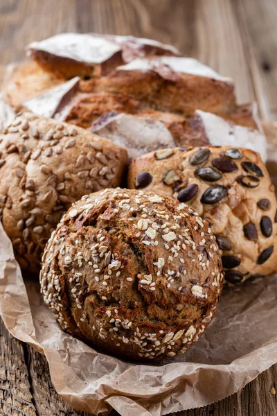 Золотий сільський хліб з хліба і булочок на дерев'яному фоні — стокове фото