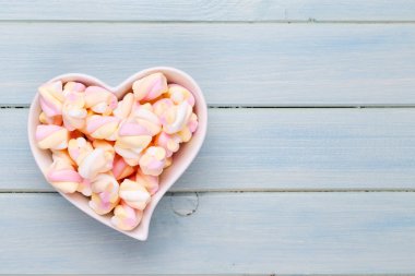 Marshmallow boşaltmak mavi zemin üzerine. Düz yatıyordu veya üst 